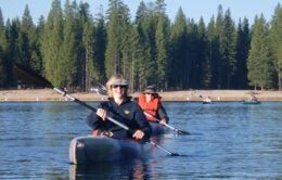 Two kayakers on Pinecrest Lake at Lair of the Golden Bear