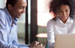 Mixed race female mentor hr manager consulting african american client teaching intern new employee with laptop, black designer advisor make business offer to customer showing computer presentation