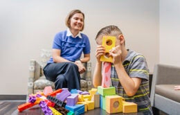 Child playing with blocks next to his mother