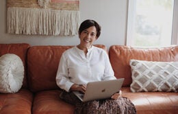 Woman sitting on couch with laptop