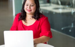 Woman in red dress working on laptop