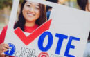 Student holding vote sign