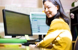 Woman in yellow sweater at computer