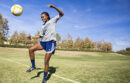 Girl kicking a soccer ball with her knees