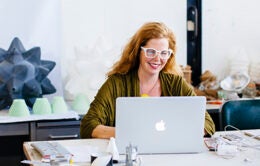 Smiling woman working on laptop computer