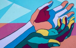 Photograph of mural containing multicolored hands coming together