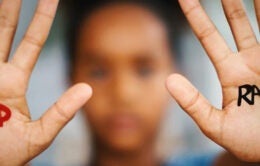 Person holding up hands with the words "stop racism" written on them