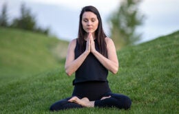 Woman meditating on lawn