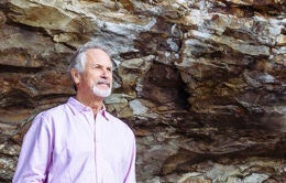 Man standing in front of rock