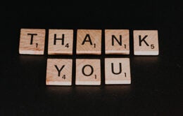 scrabble tiles spelling the words "thank you"