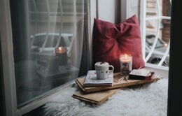 Cozy windowseat with pillow, candle and hot cocoa