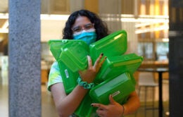 Student worker carries reusable takeout containers
