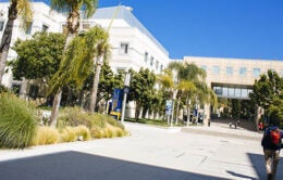 student walking across UC Irvine's campus