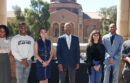 President Drake standing, smiling with a diverse group of UCLA students