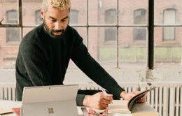 Man taking notes and working at a desk