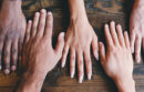 Hands placed together with various skin tones