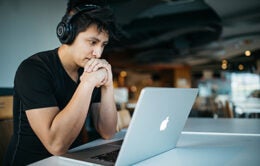 Man wearing headphones looking at laptop