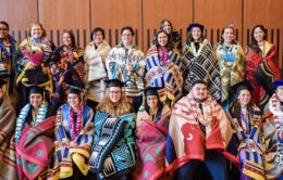 Native American graduate students wearing traditional blankets