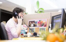 Woman sitting on desk talking on telephone