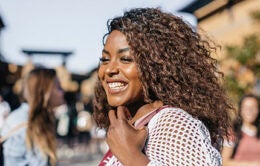 Smiling woman walking with shoulder bag