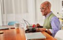 Older man working on a laptop at a table