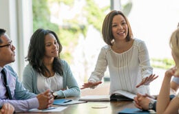 A group of young business professionals attending a presentation in a board room.