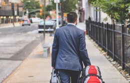 Man walking down the street carrying luggage