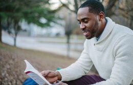 Man reading a book outside