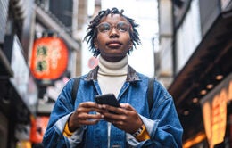 Woman walking down the street holding her cellphone
