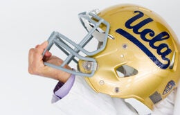 Hand holding UCLA football helmet