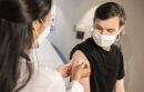 CDC photo of doctor putting a band-aid on man's arm after flu shot