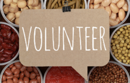 The word "volunteer" atop several cans of food