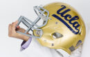 Hand holding UCLA football helmet