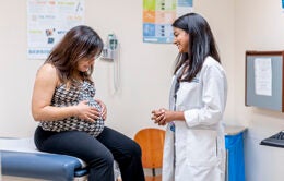 Female doctor consulting with pregnant patient