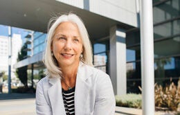 Woman facing the camera wearing a white coat
