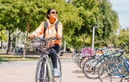 Smiling UC Davis student riding a bike on campus