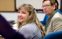 Smiling woman sitting in a conference room at UCOP