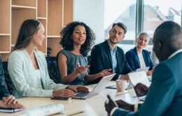 Multiethnic group of businesspeople sitting together and having a meeting in the office.
