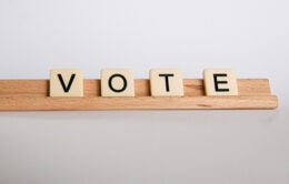scrabble tiles spelling "vote"
