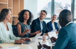 Multiethnic group of businesspeople sitting together and having a meeting in the office.