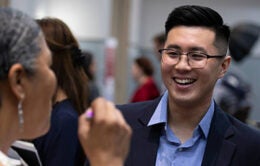Young man talking to woman at career fair in 2019