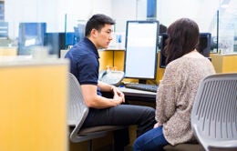 People having a conversation in front of a computer