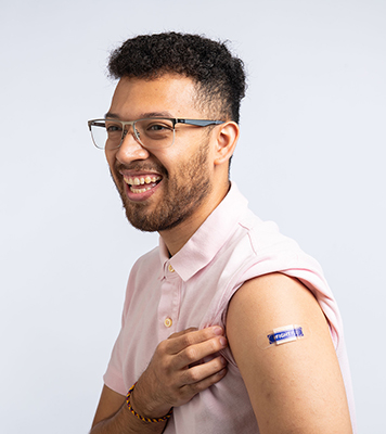 Smiling man wearing a flu shot bandaid