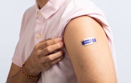 Man revealing band-aid with the words "fight flu" on it