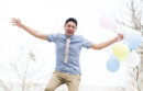 Man jumping and holding balloons