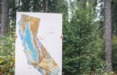 UC Santa Cruz student holding a topical and waterways map of CA
