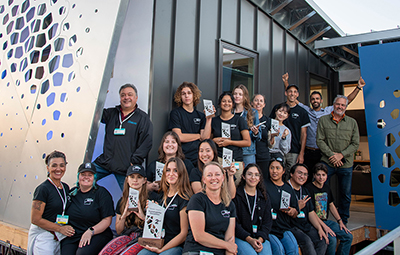 UC Irvine students and staff pose in front of the luminOCity house they built. 