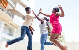Three women excitedly jumping in the air together