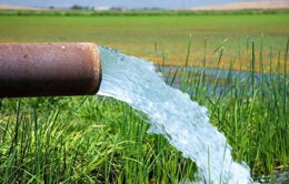 Water overflowing from a pipe onto a field