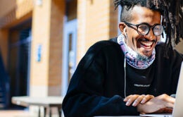 Smiling man working on laptop computer